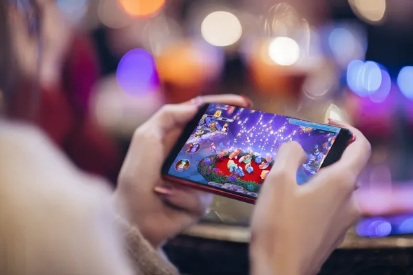 App 1CCC — Aproveite jogos sem interrupções no seu smartphone Uma jovem relaxando com o celular enquanto elementos dinâmicos de cassino flutuam ao seu redor, ilustrando a experiência móvel fluida oferecida pelo app 1CCC.