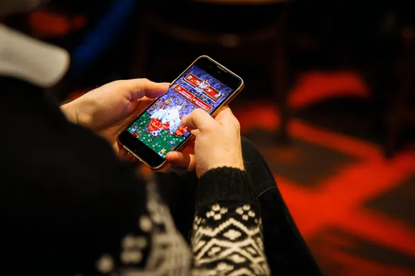 App Móvel 1CCC — Seu hub completo para cassino e esportes Um homem concentrado em seu laptop com estatísticas ao vivo ao fundo, destacando os recursos dedicados de esportes e jogos do app móvel 1CCC.